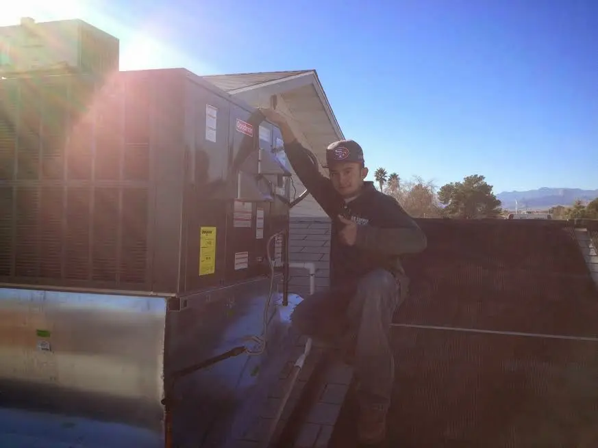 HVAC technician performing Heat Pump Repair on a rooftop unit in Walkertown